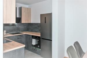 萨格勒布Špansko view -Comfy apartment的厨房配有不锈钢冰箱和木制橱柜