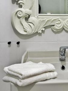 阿斯蒂Il Bumbunin Esclusivo monolocale nel cuore di Asti的浴室设有水槽上的白色毛巾