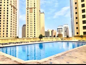 迪拜Jbr Sea View Captivating 4-Bed Apartment in Dubai的一座位于城市的游泳池,有高大的建筑