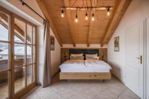 加尔米施-帕滕基兴Ferienhaus Die 12 mit 4 Schlafzimmern in Garmisch的一间卧室设有一张床和木制天花板