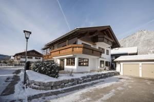 加尔米施-帕滕基兴Ferienhaus Die 12 mit 4 Schlafzimmern in Garmisch的雪中带木屋顶的白色房子