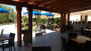 维耶斯泰Hotel Residence Villa Ascoli的一个带桌椅和蓝伞的庭院