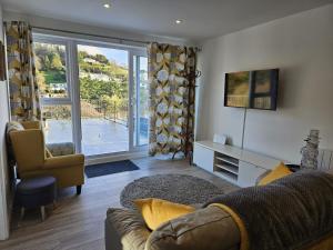西卢港Pet Friendly Sea view Villa Millendreath Looe的带沙发和滑动玻璃门的客厅