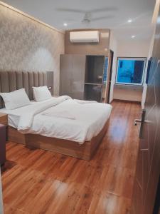 勒克瑙Hotel Sharma Regency的一间卧室设有一张大床,铺有木地板