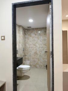 勒克瑙Hotel Sharma Regency的浴室配有白色卫生间和石墙。