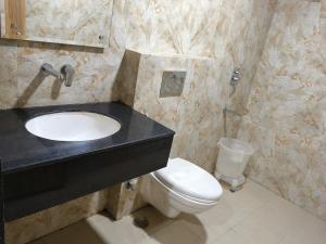 勒克瑙Hotel Sharma Regency的一间带黑色水槽和卫生间的浴室