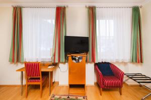 PredlitzFerien beim Steiner的客厅配有桌子、两把椅子和电视