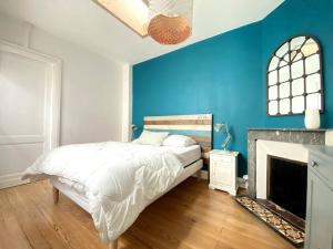 阿卡雄Villa familiale à Arcachon plage的蓝色卧室设有一张床和一个壁炉