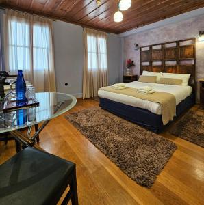 纳夫普利翁Kallisti Luxury rooms的一间卧室配有一张床和一张玻璃桌