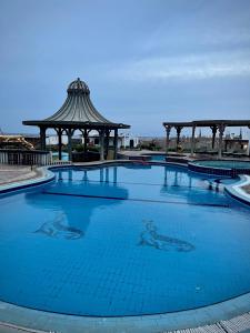 达哈布Black Prince Hotel的一个带凉亭的大型蓝色游泳池