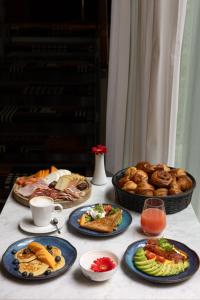 卢森堡Hotel Le Place d'Armes - Relais & Châteaux的餐桌上放有食物和面包的盘子