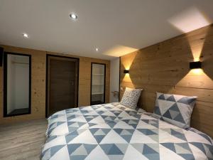 比桑Gîte Au Creux Du Moulin的一间卧室设有一张大床和木墙