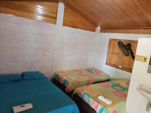 比利亚维哈Hostal Sol de Verano Doña Lilia的小房间设有两张床和盥洗盆