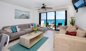 坎昆Perfect vacation getaway,Ocean View,Wifi, Beach的客厅配有沙发和桌子