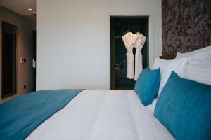 勒马兰Sable Bleu Boutique Hotel的卧室配有带蓝色枕头的大型白色床