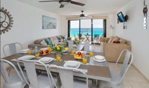 坎昆Perfect vacation getaway,Ocean View,Wifi, Beach的用餐室以及带桌椅的起居室。