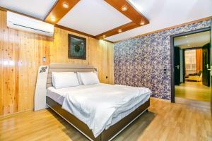 巴库View Nizami Street Chapman Taylor Baku的卧室配有一张床铺,位于带木墙的房间内