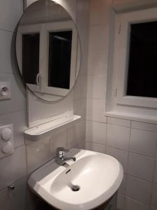 拉佩蒂特皮耶尔Gîte La Rose Jacuzzi Nordique的浴室设有白色水槽和镜子