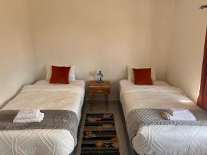 利文斯顿White Rhino apartments & tours的带2张单人床的带边桌的客房