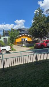 科伊艾科Hostal Sur Y Magia的一条街道,在黄色房子前面停有汽车