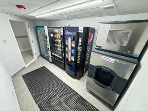 东叙拉古Studio 6 Suites East Syracuse NY Airport的一间设有自动售货机和饮料冷却器的房间