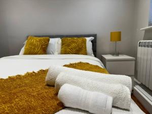凯特林Rest Haven Lodge的一间卧室配有带白色床单和黄色枕头的床。
