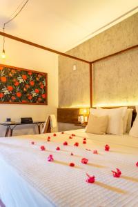 杰里科科拉Casa Valentini Pousada的一间卧室,床上有红色的鲜花