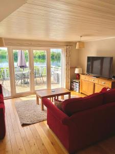 南塞尔尼The Cotswolds Lakeside - Kinsale Lodge,Spring Lake的客厅配有红色沙发和电视