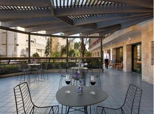 耶路撒冷普瑞玛国王酒店 的庭院配有两把桌椅和酒杯