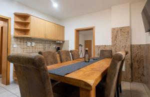 HauWork & Stay Apartment Bedburg Hau的一间带木桌和椅子的用餐室