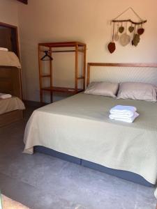 博尼图Chalé Buriti的一间卧室配有一张大床,上面有毛巾