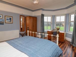 LlanwrdaTirallen的一间卧室配有一张带蓝色棉被的床