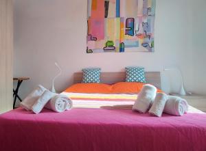 特拉帕尼Sea view的一间卧室配有粉红色的床和毛巾