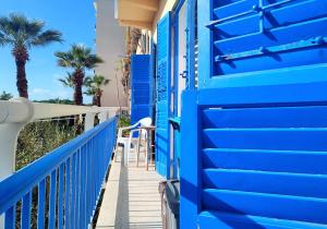 特拉帕尼Sea view的棕榈树阳台上的蓝色建筑