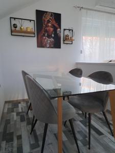 拉克塔希Apartman Mihaela的一间设有玻璃桌和椅子的用餐室