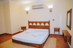 法尤姆Tunis Beach Families Only的一间卧室配有一张床、一张书桌和一个窗户。