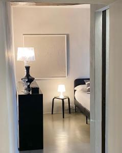 锡耶纳Palazzo del Papa Country Suites的一间卧室配有一张床和一张带台灯的桌子