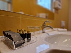 考纳斯Hotel Sfinksas的浴室设有水槽,并在柜台上提供5瓶水