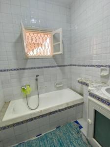 莫纳斯提尔Omnia House的白色的浴室设有浴缸和窗户。