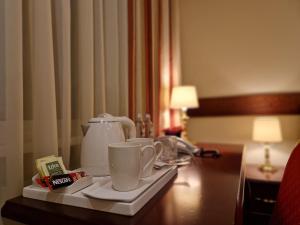 考纳斯Hotel Sfinksas的一间酒店客房内的茶盘,上面有杯子