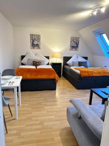居特斯洛Modern Apartment in Gütersloh Avenwedde的客房设有两张床、一张桌子和一张沙发。