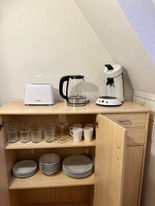 居特斯洛Modern Apartment in Gütersloh Avenwedde的架子上装有盘子和咖啡壶