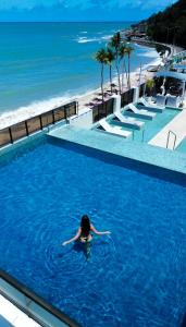 若昂佩索阿卡博布兰科阿特兰蒂克酒店的妇女在海滩旁的游泳池游泳