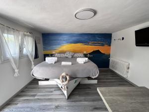 坎丕里亚麦利蒂玛43° Parallelo的卧室配有一张床,墙上挂有绘画作品
