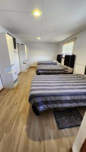 兰卡瓜Residencial F y V Spa的铺有木地板的客房内的两张床