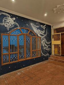 蓬蒂切里Unpack Hostel的一间设有墙壁的房间,设有门和壁画