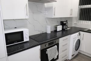达特福德Ground Floor 1 Bed Flat Dartford- 1 - Fully Equipped - Fibre Wifi的白色的厨房配有微波炉和洗碗机。