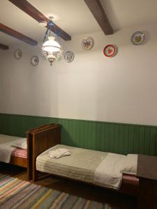 巴亚马雷Pensiunea Iona的卧室配有两张床和墙上的盘子。