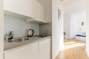 萨格勒布Niva Rooms & Studio Apartment的厨房配有白色橱柜和水槽