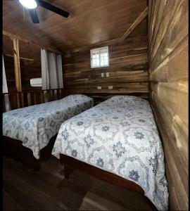 Alto BoqueteLas cabañas del Francés的小木屋内一间卧室,配有两张床